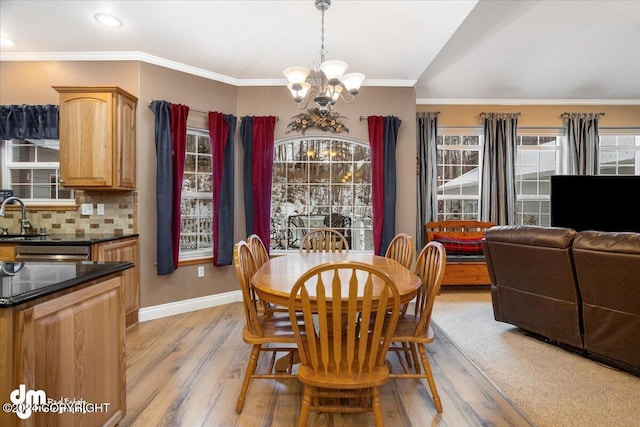 dining room featuring lofted ceiling, a notable chandelier, crown molding, and light hardwood / wood-style floors