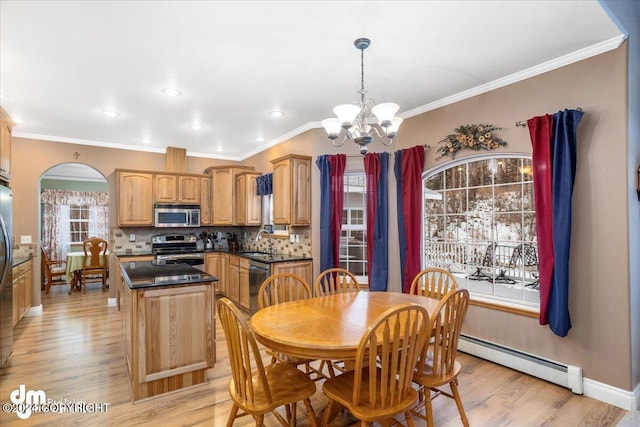 dining area with an inviting chandelier, a baseboard heating unit, light hardwood / wood-style floors, and sink