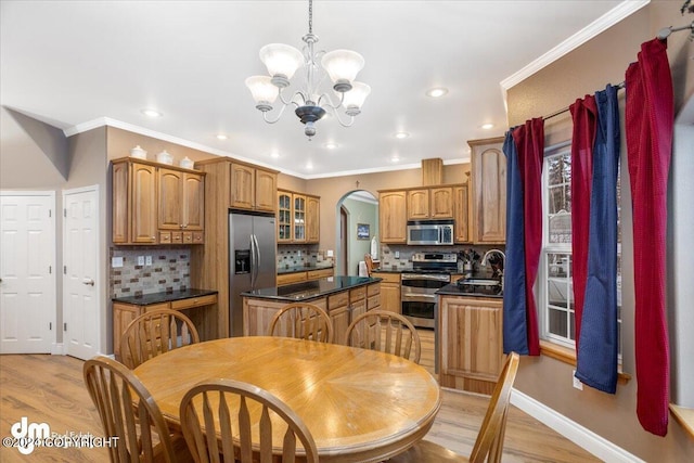 kitchen featuring decorative light fixtures, ornamental molding, and appliances with stainless steel finishes