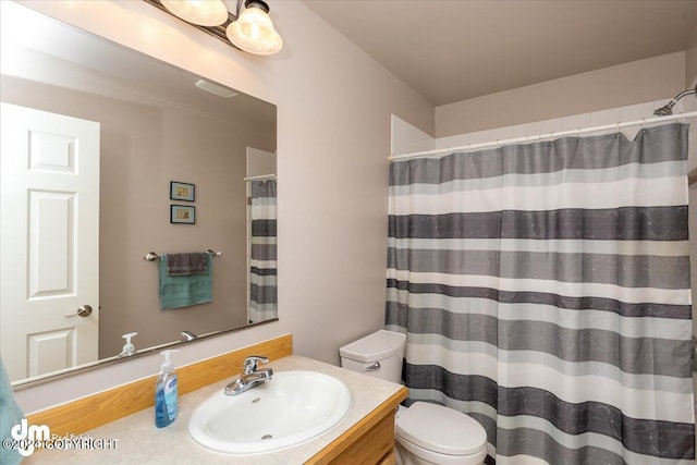 bathroom with a shower with curtain, vanity, and toilet