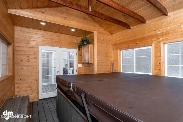 interior space with light brown cabinetry, vaulted ceiling with beams, wooden walls, and wooden ceiling