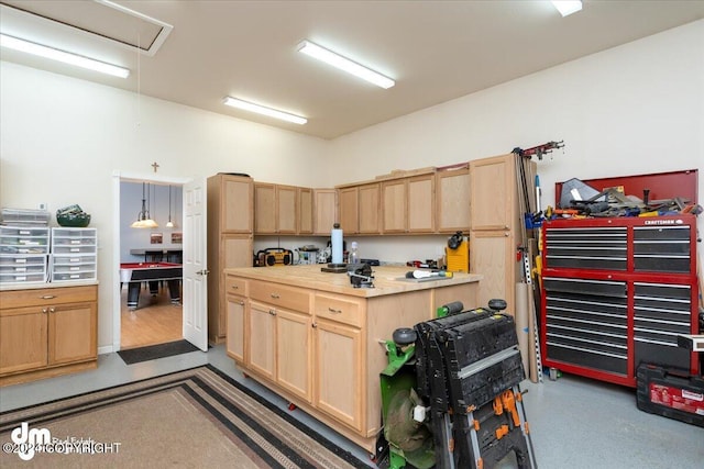 kitchen with hanging light fixtures and light brown cabinetry