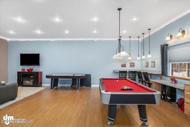 recreation room with pool table, ornamental molding, and light wood-type flooring