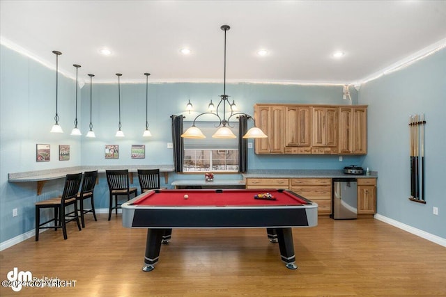 recreation room with billiards, ornamental molding, and light hardwood / wood-style flooring