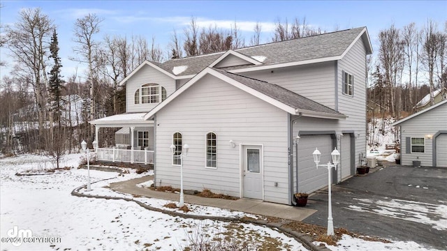 view of property featuring a garage and covered porch