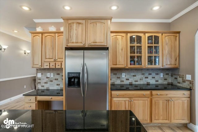 kitchen featuring glass insert cabinets, crown molding, stainless steel fridge, and backsplash