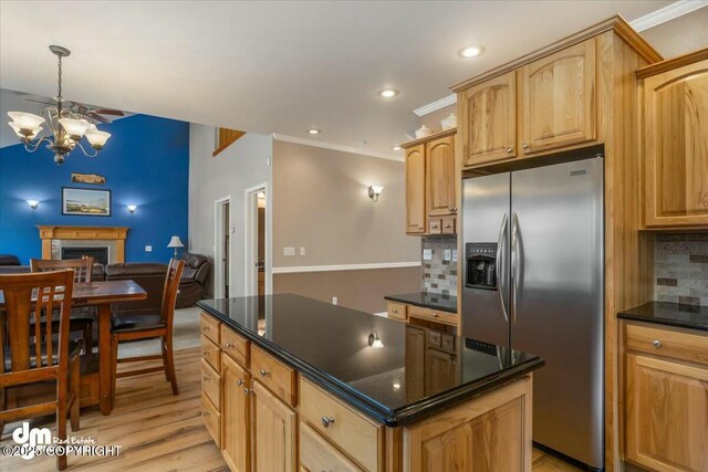 kitchen with light wood finished floors, a notable chandelier, stainless steel refrigerator with ice dispenser, backsplash, and open floor plan