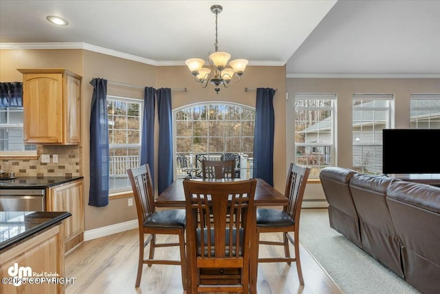 dining space with a baseboard heating unit, an inviting chandelier, light wood-style flooring, baseboards, and ornamental molding