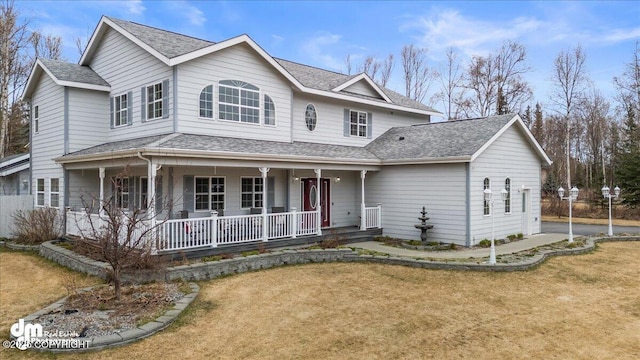 view of front facade with covered porch, a shingled roof, and a front lawn
