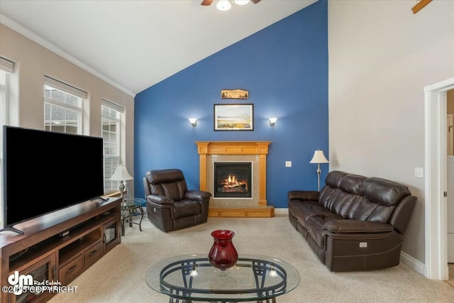 carpeted living area featuring ceiling fan, high vaulted ceiling, a glass covered fireplace, baseboards, and ornamental molding