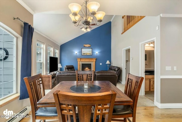 dining room with an inviting chandelier, a warm lit fireplace, a baseboard radiator, light wood finished floors, and baseboards