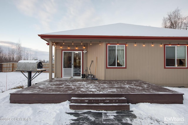 snow covered property with a deck