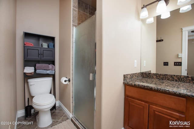 bathroom featuring toilet, vanity, tile patterned floors, and walk in shower