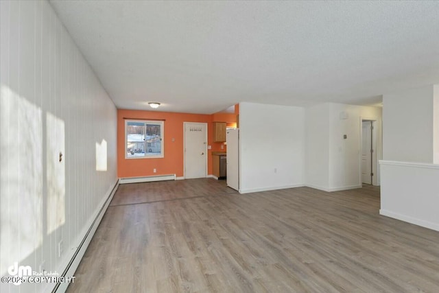 unfurnished living room with a baseboard heating unit, a textured ceiling, and light wood-type flooring