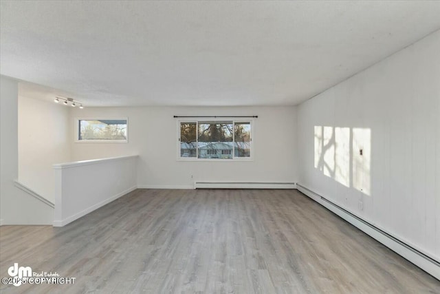 spare room with light hardwood / wood-style flooring and a baseboard heating unit