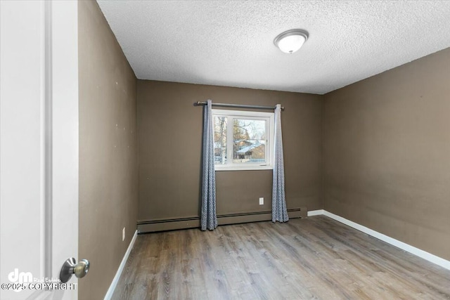 empty room with a textured ceiling and light wood-type flooring