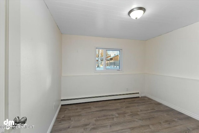 spare room with a baseboard radiator and hardwood / wood-style floors