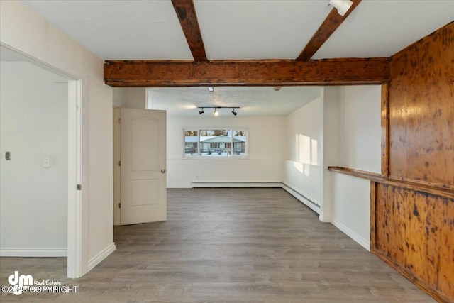 unfurnished room with a baseboard heating unit, wood-type flooring, beamed ceiling, and track lighting