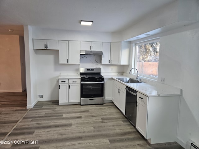 kitchen with white cabinetry, stainless steel range, sink, dishwasher, and a baseboard heating unit