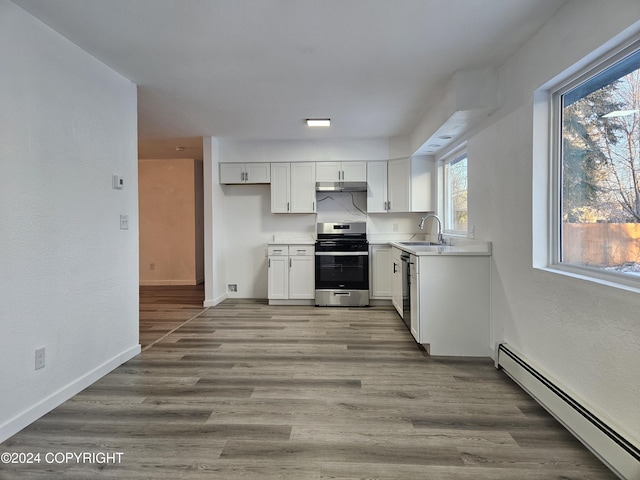 kitchen featuring stainless steel appliances, baseboard heating, sink, white cabinets, and light hardwood / wood-style floors