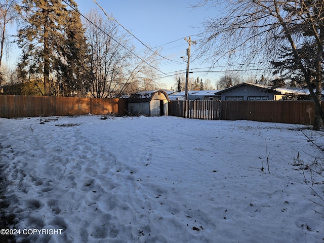 snowy yard featuring an outbuilding