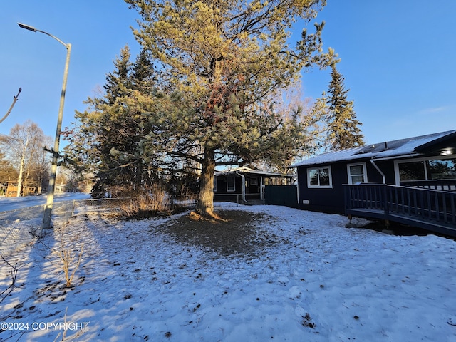 snowy yard featuring a wooden deck