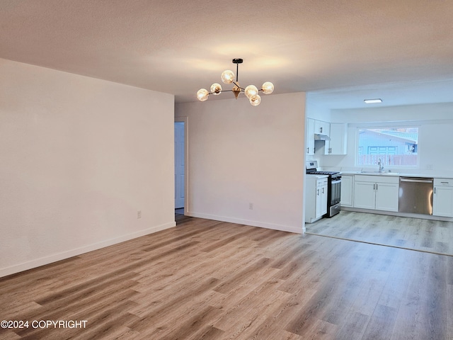 interior space with white cabinetry, sink, stainless steel appliances, an inviting chandelier, and light wood-type flooring