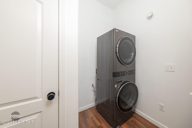 washroom featuring stacked washing maching and dryer and dark hardwood / wood-style floors