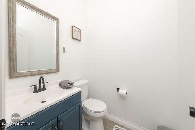 bathroom with vanity, hardwood / wood-style flooring, and toilet