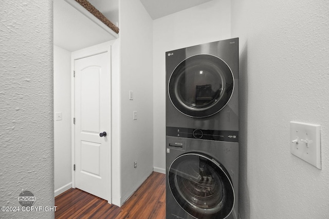 washroom with dark hardwood / wood-style floors and stacked washer and dryer