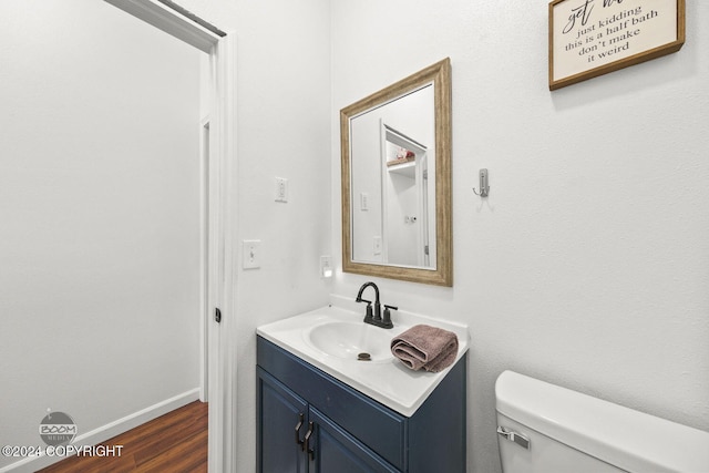 bathroom featuring hardwood / wood-style floors, vanity, and toilet