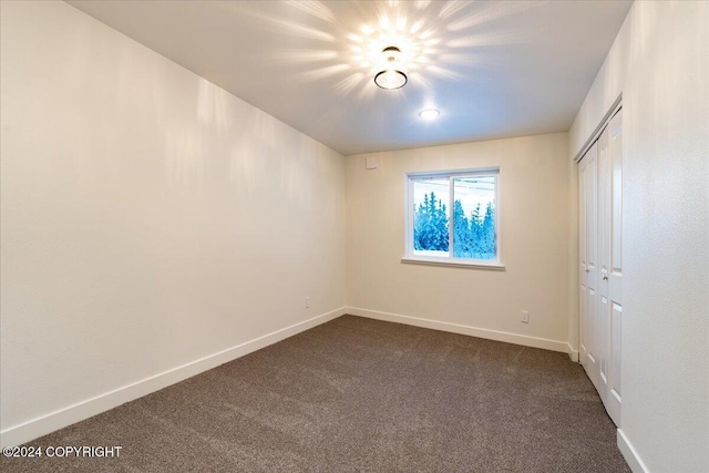 spare room featuring dark colored carpet