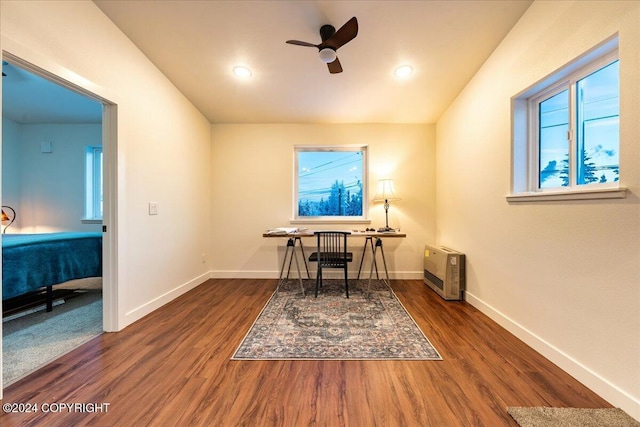 office with dark hardwood / wood-style floors, ceiling fan, and heating unit