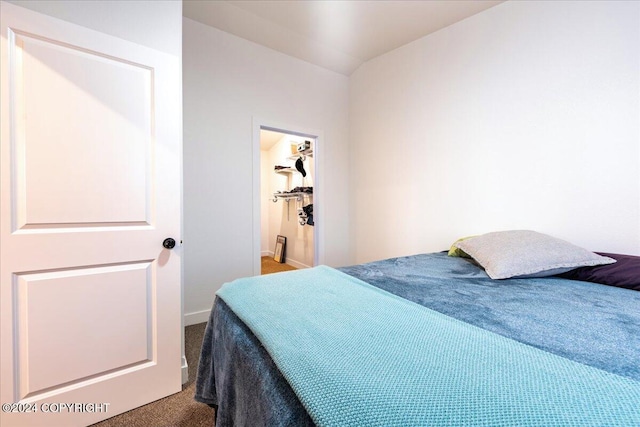 carpeted bedroom with vaulted ceiling and a spacious closet