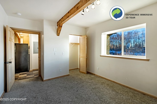 unfurnished bedroom with beamed ceiling, electric panel, dark carpet, and a closet