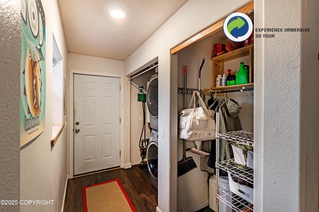 laundry room featuring dark hardwood / wood-style flooring and stacked washer / dryer