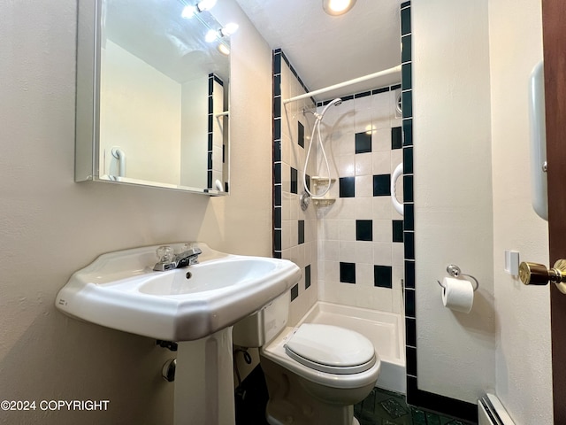 bathroom featuring a baseboard heating unit, toilet, and tiled shower