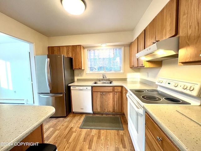 kitchen with sink, white appliances, light wood-type flooring, and a baseboard heating unit