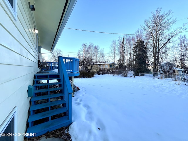 yard covered in snow with a deck