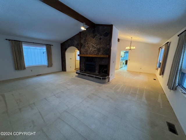 unfurnished living room featuring visible vents, a tiled fireplace, lofted ceiling with beams, carpet, and a textured ceiling