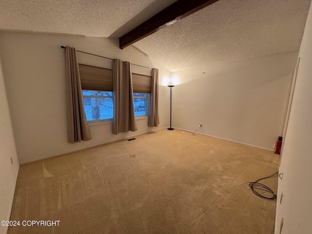 unfurnished room with vaulted ceiling with beams, a textured ceiling, and carpet flooring