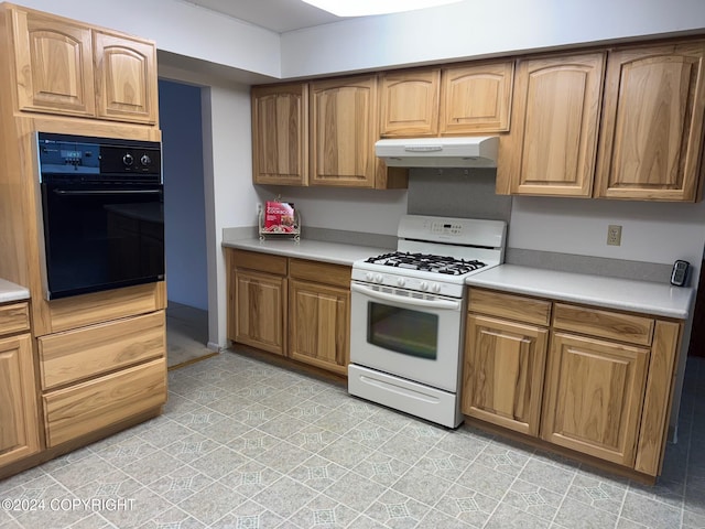 kitchen featuring under cabinet range hood, white gas range, light countertops, and oven