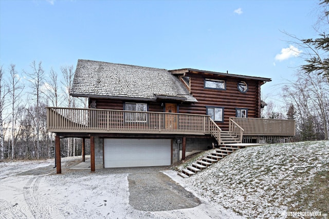 snow covered property featuring a deck and a garage