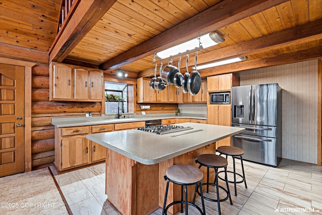 kitchen with wooden ceiling, appliances with stainless steel finishes, log walls, a kitchen island, and beam ceiling