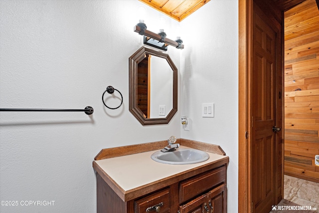 bathroom featuring vanity and wood walls