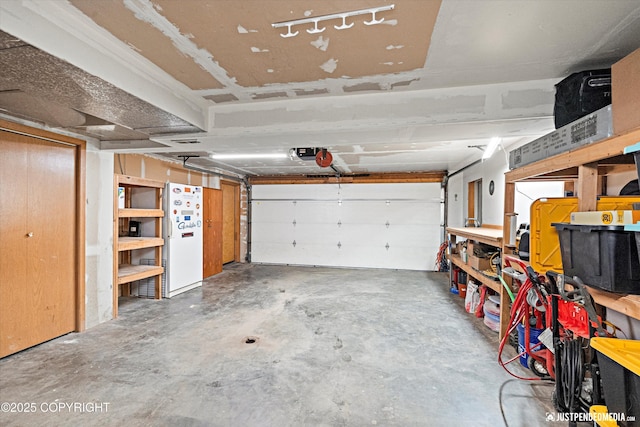 garage with a garage door opener and white refrigerator