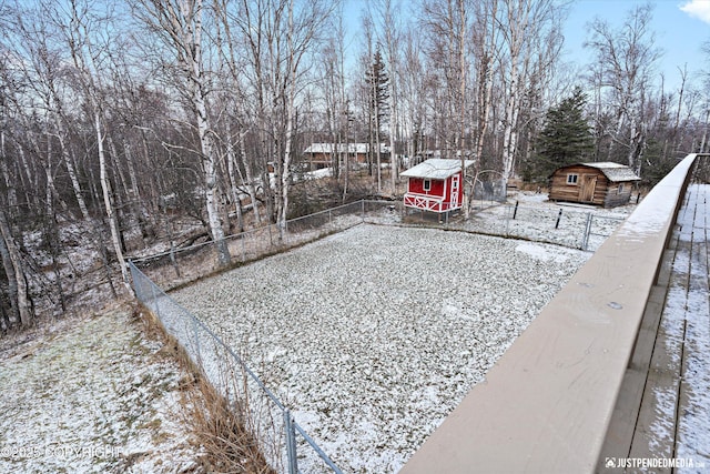 yard covered in snow featuring a shed