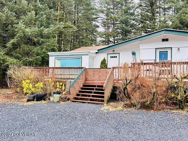 3411 Monashka Bay Rd, Kodiak, AK 99615 - view of front of property with stairway, a deck, and an attached garage