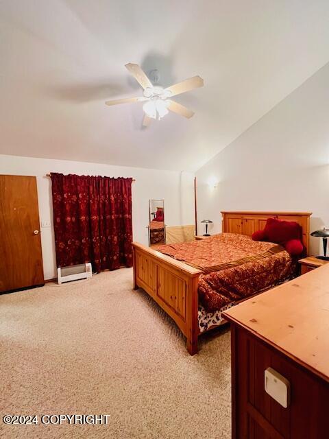 3411 Monashka Bay Rd, Kodiak, AK 99615 - bedroom with vaulted ceiling, light carpet, a baseboard radiator, and ceiling fan