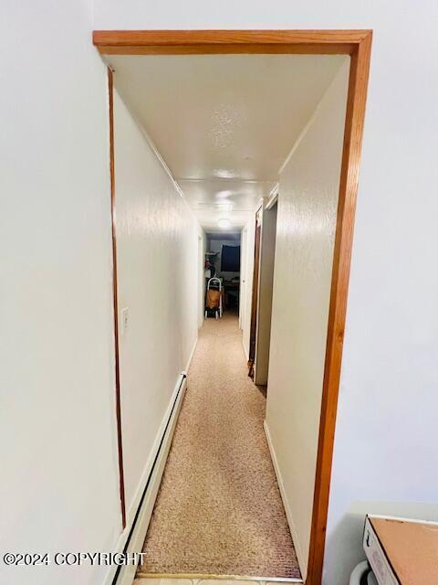 3411 Monashka Bay Rd, Kodiak, AK 99615 - corridor with a baseboard heating unit and light colored carpet